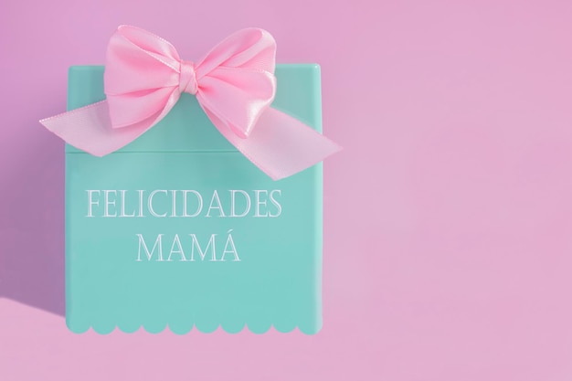 Uma caixa rosa e azul com um laço rosa que diz "mamães felizes".