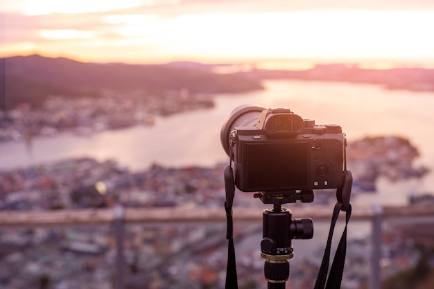 Uma câmera no tripé está fotografando a bela vista no crepúsculo