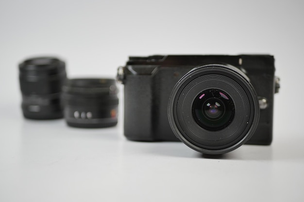 Uma câmera sem espelho de cor preta e lente em fundo branco