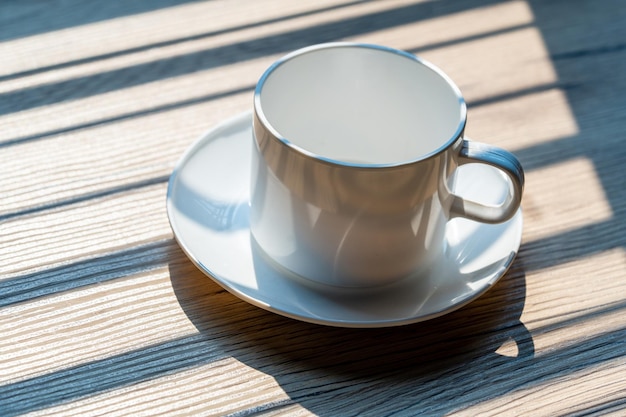 Uma caneca de café branca é colocada na mesa do escritório