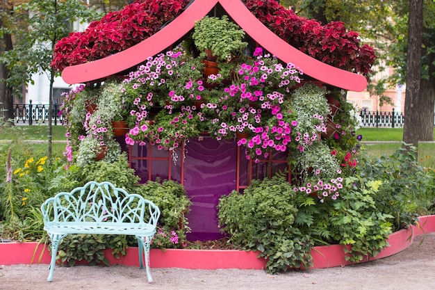 uma casa de flores no parque com um banco paisagismo decorado parque na cidade