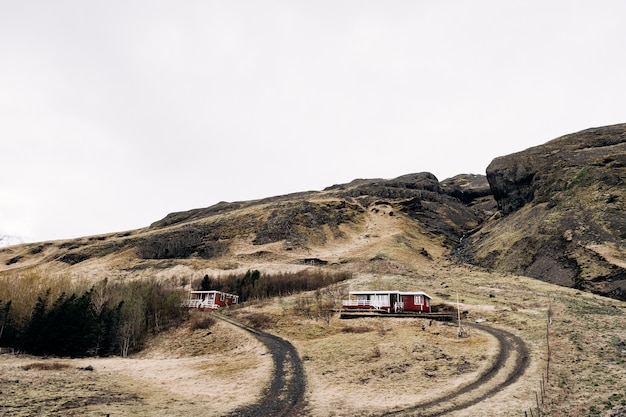 Uma casa de madeira vermelha no sopé de uma montanha na islândia