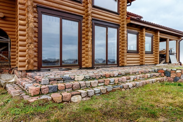 Uma casa de toras de madeira nas margens de um grande lago Construção em andamento