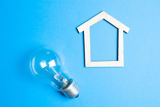 Foto uma casa e uma lâmpada em um fundo azul conceito eco em casa