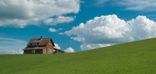 uma casa em uma colina com um fundo de céu