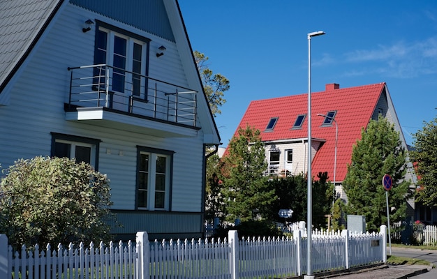 Uma casa particular de dois andares com telhado triangular e uma área perto da casa contra um céu azul