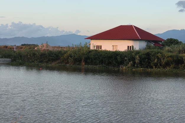 Uma casa perto da água com um telhado vermelho