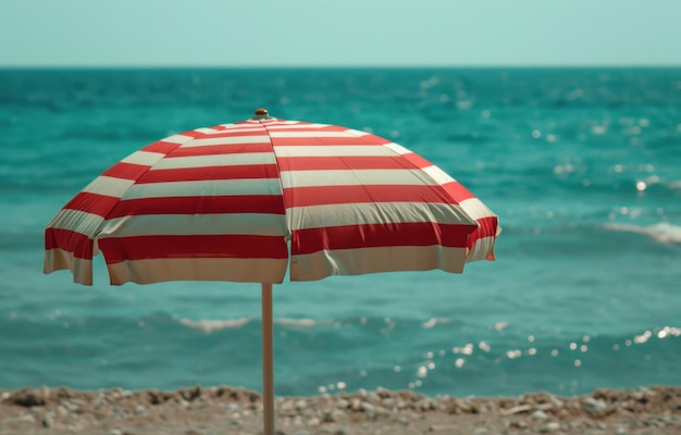 uma cena de praia com um guarda-chuva listrado vermelho e branco