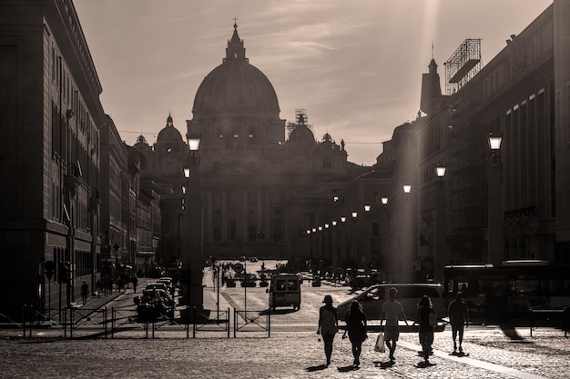 Uma cena de rua com uma cúpula ao fundo Vaticano Roma Itália