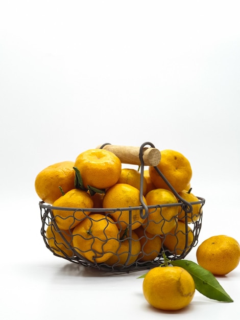 Uma cesta de laranjas com uma folha verde ao lado