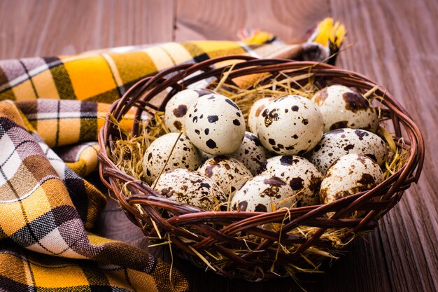 Uma cesta de ovos de codorna e guardanapo em uma mesa de madeira