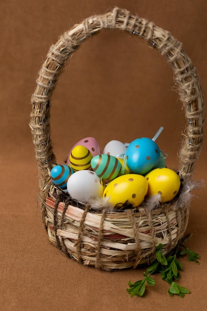 Uma cesta de ovos de páscoa com uma pena verde ao lado.