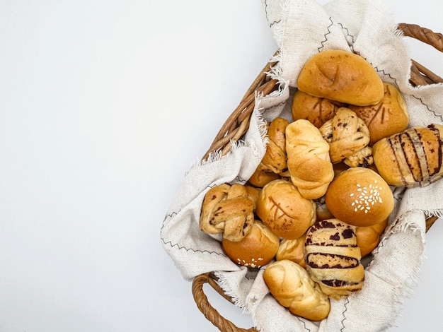 Uma cesta de pães com um pano branco ao fundo