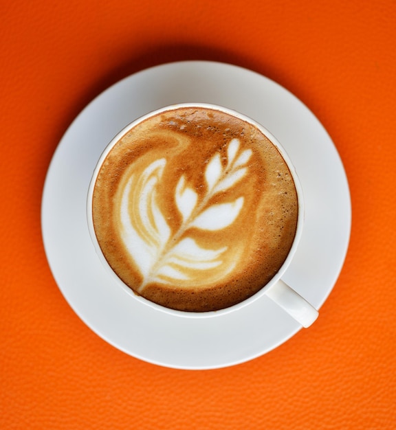 Uma chávena de café com leite quente na mesa.