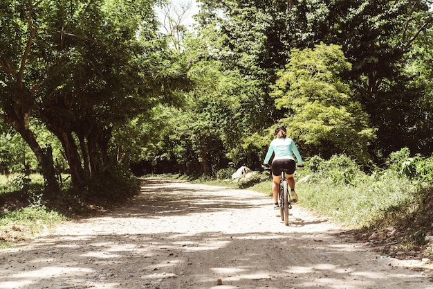 uma ciclista feminina andando de bicicleta correndo em um conceito de mountain bike de estrada de terra