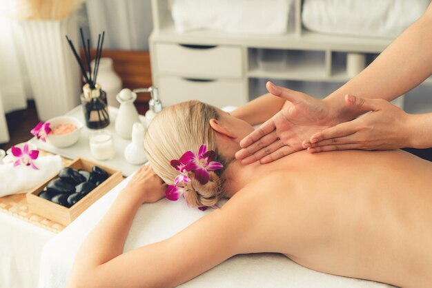 Uma cliente caucasiana a desfrutar de uma massagem anti-estresse relaxante.