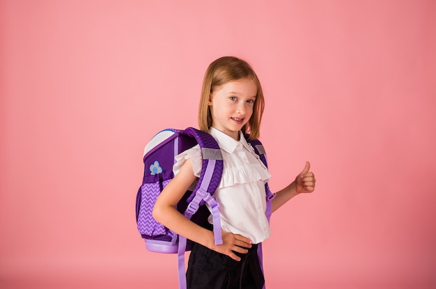 Uma colegial de uniforme e com uma mochila se levanta e mostra uma turma em um fundo rosa com uma cópia do espaço