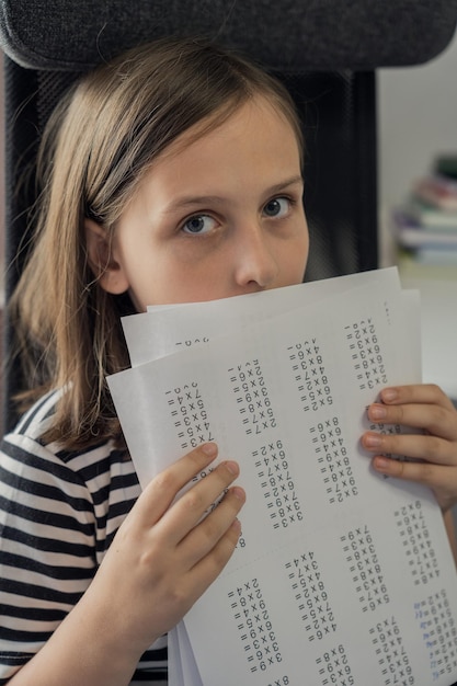 Uma colegial faz a lição de casa em casa. O conceito de volta às aulas.