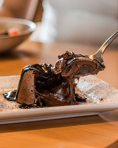 Uma colher de bolo de chocolate em um prato com um garfo