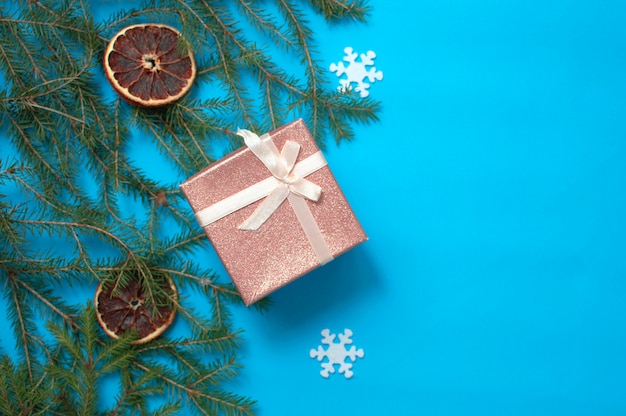 Uma composição de Natal em um fundo azul, uma moldura de galhos de árvores de Natal e brinquedos de árvores de Natal no fundo são isolados em um fundo branco. Espaço para texto.