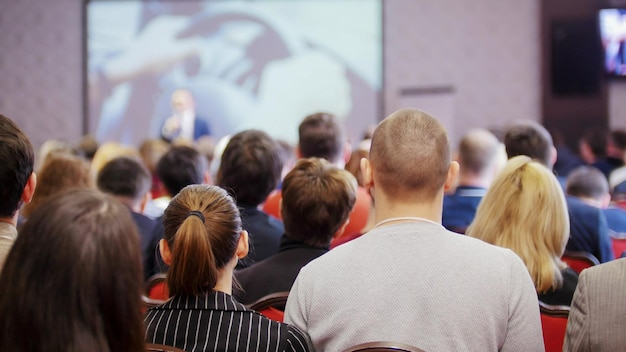 Uma conferência de negócios pessoas sentadas nas cadeiras e assistindo a apresentação no corredor