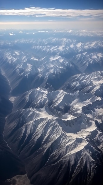 Uma cordilheira está coberta de neve e o céu é azul.