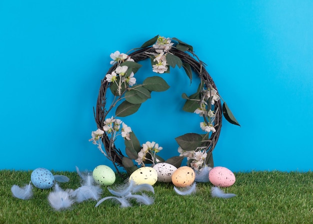 Uma coroa de ovos de páscoa com um galho de árvore e flores na frente.