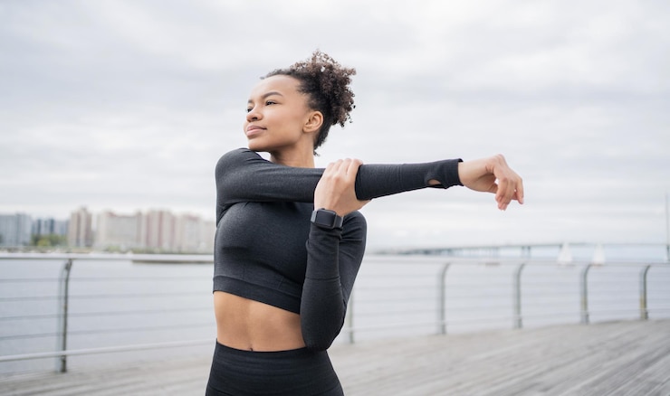 Foto uma corredora esportiva usa um relógio de fitness para treinamentoo treinador de corrida está vestindo um agasalho