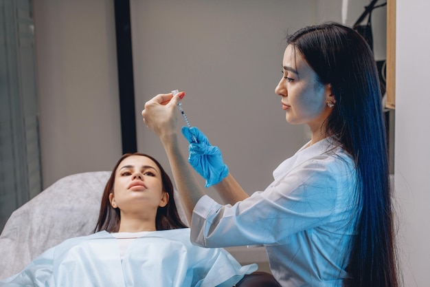 Uma cosmetologista feminina prepara uma seringa para o procedimento de aumento dos lábios. Cuidando da beleza.