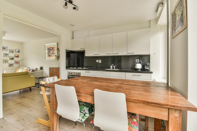 Foto uma cozinha com mesa de madeira e cadeiras brancas