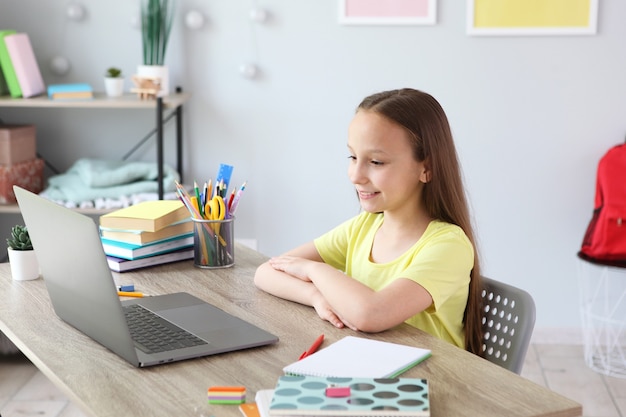 Uma criança aprende online em casa por meio de um laptop moderno na Internet