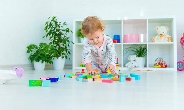 Uma criança brinca com brinquedos na sala de jogos Foco seletivo Kid