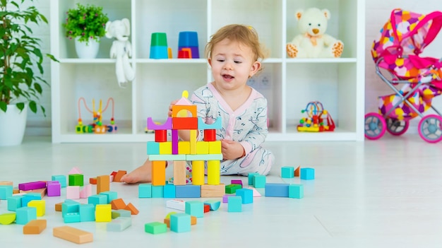 Uma criança brinca com brinquedos na sala de jogos foco seletivo kid