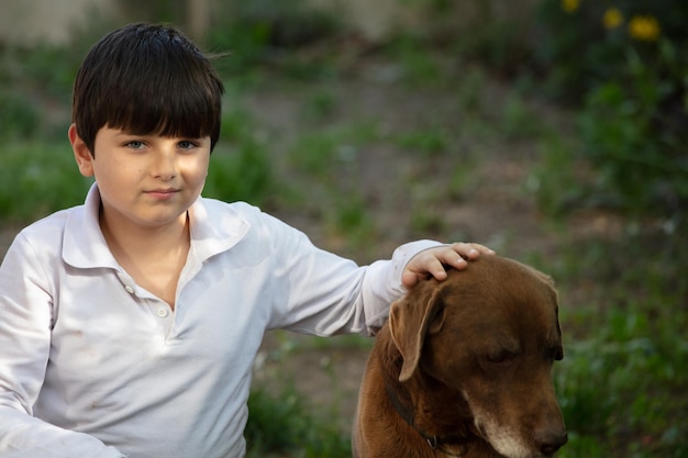 Uma criança brinca com um cachorro no jardim