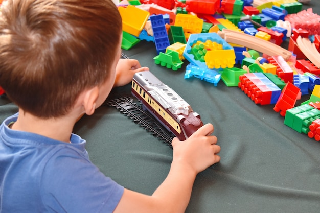 Uma criança brinca com um trem de brinquedo. construtor de desenvolvimento infantil.