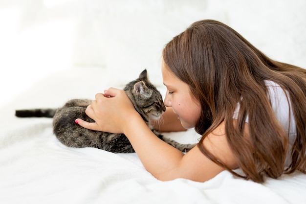 Uma criança brincando com o gato em casa