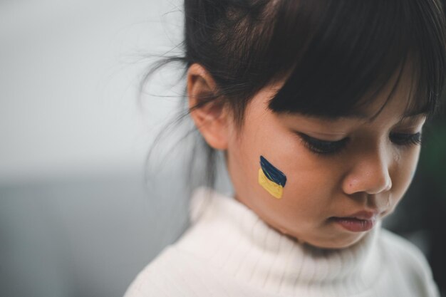 Uma criança com a bandeira da Ucrânia está chorando Tristeza saudade esperança Lágrimas de crianças da guerra Evacuação de civis Liberdade para a Ucrânia