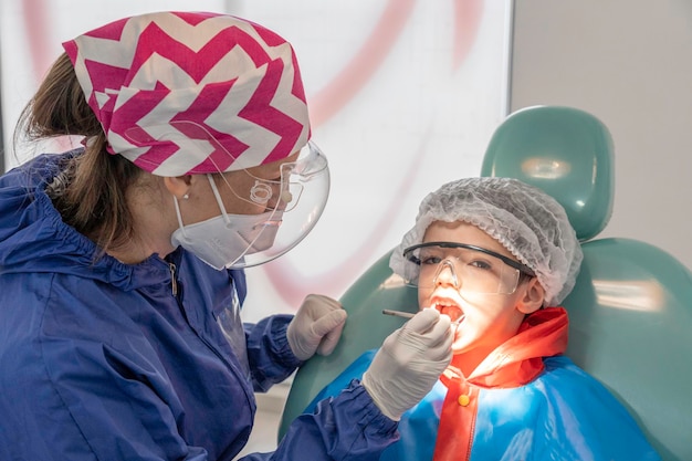 Uma criança com um dentista em um consultório odontológico. tratamento odontológico em clínica infantil.