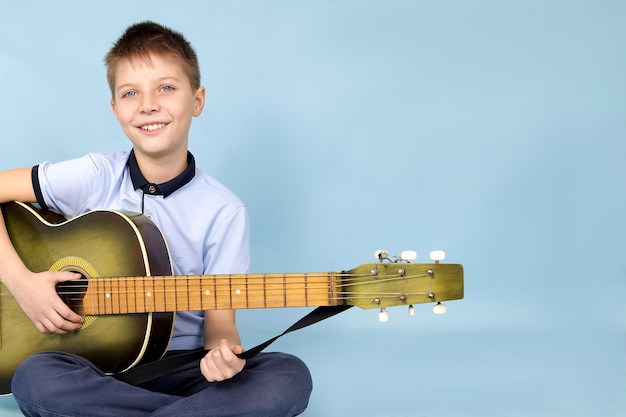 Uma criança com uma guitarra em um fundo azul