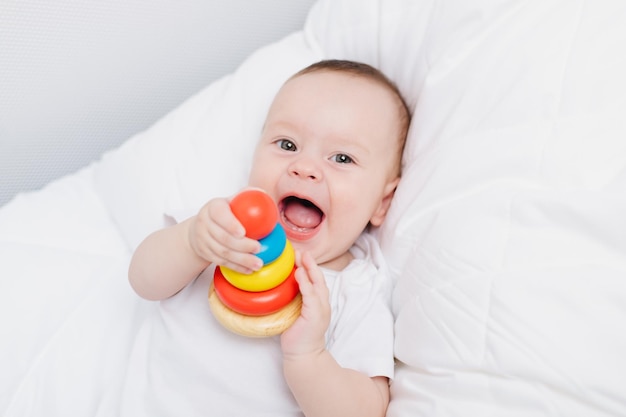 Uma criança com uma pirâmide de madeira bebê feliz brinquedos infantis