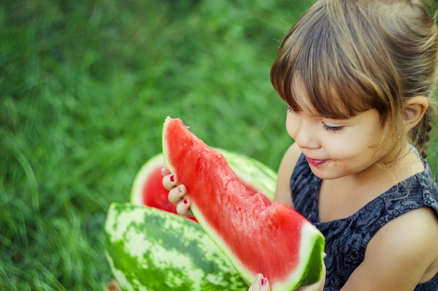 Uma criança come melancia. Foco seletivo. natureza.