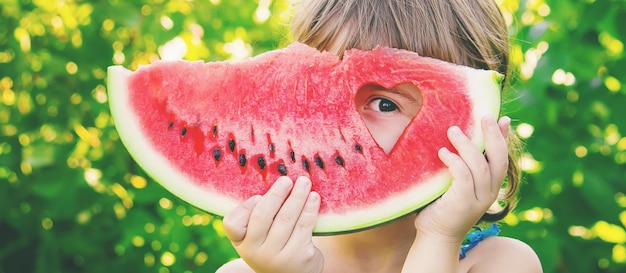 Uma criança come melancia. foto. comida