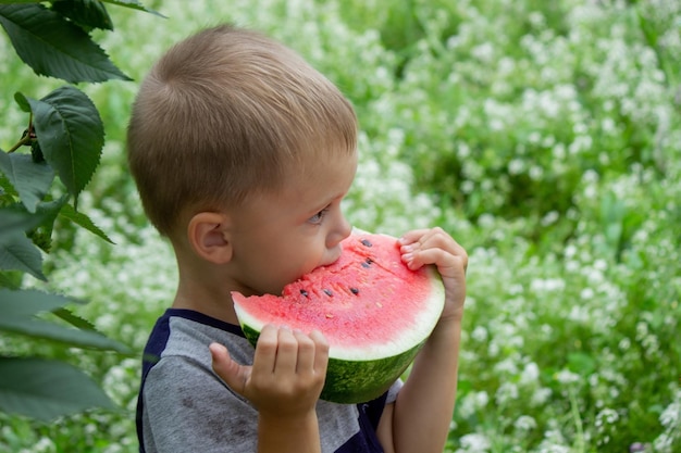 Uma criança come uma melancia Foco seletivo