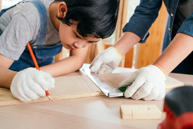 Uma criança e um adulto trabalham juntos em um projeto de carpintaria com foco em medições e desenhos