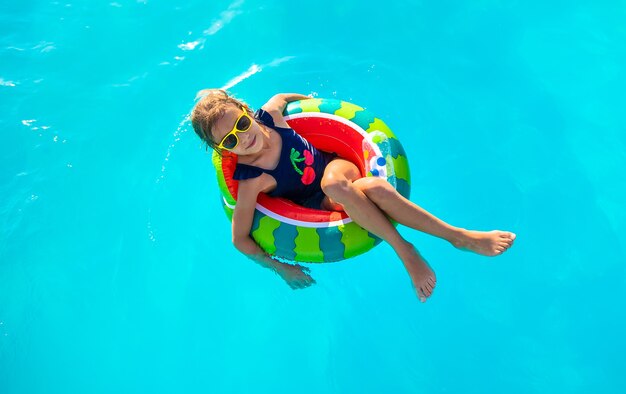 Uma criança em círculo nada na piscina. Foco seletivo. Miúdo.