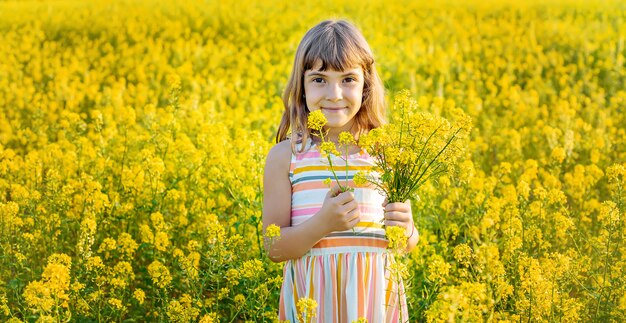 Uma criança em um campo amarelo, mostarda floresce
