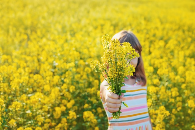 Uma criança em um campo amarelo, mostarda floresce