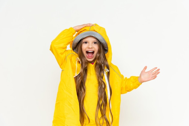 Uma criança em uma capa de chuva em um fundo branco isolado Uma menina com cabelo comprido em uma capa de chuva amarela e um chapéu panamá