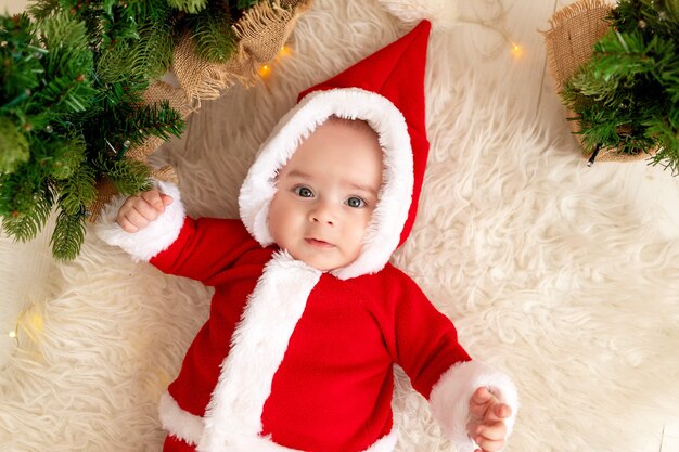 Uma criança está deitada perto da árvore de Natal com acessórios de Natal ano novo e conceito de Natal