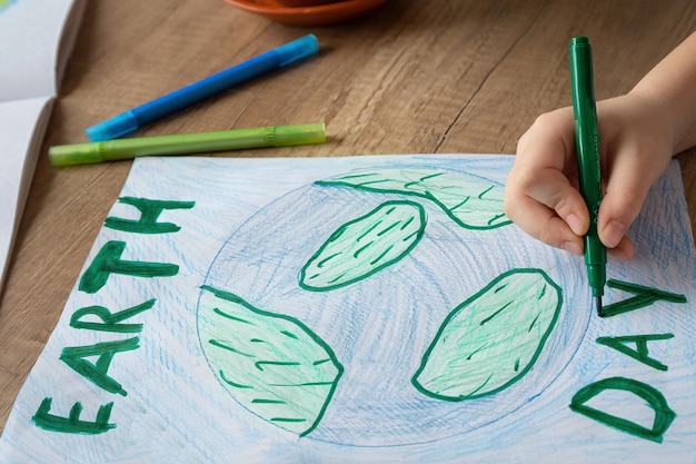 Uma criança está desenhando uma terra verde com as palavras terra nela.